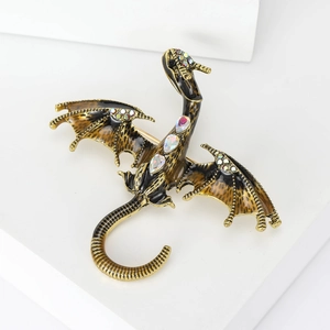 Close-up of golden dragon brooch featuring detailed enamel scales and sparkling crystals