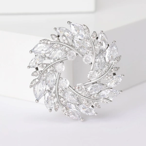 Vue détaillée d'une broche couronne en zircon argenté sur un présentoir blanc minimaliste