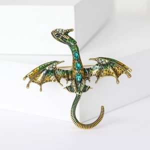 Detailed macro of golden dragon brooch with green enamel and sparkling crystal accents