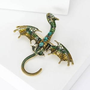 Detail of a dragon brooch in antique gold and green enamel with sparkling crystals