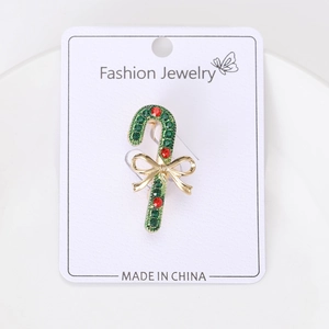 Detail of Christmas candy cane brooch with red and green rhinestones and a gold bow