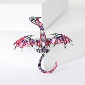 Macro detail of a purple enamel dragon brooch with colorful rhinestones on a white base