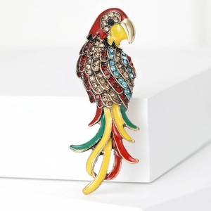Détail macro de broche perroquet avec plumes en émail et strass brillants
