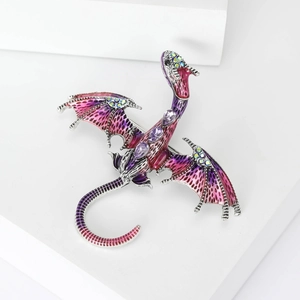 Macro shot of purple enamel dragon brooch with amethyst crystals on a white stone base