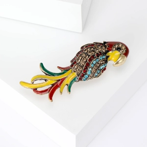 Détail de la broche perroquet avec strass colorés et émail sur une base dorée