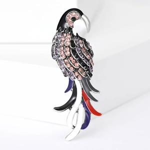 Détail de la broche perroquet avec ailes en émail coloré et strass brillants scintillants