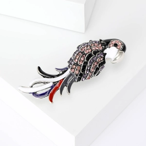 Broche perroquet étincelante avec strass colorés et émail sur support blanc