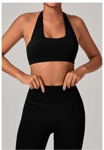 Dettaglio del reggiseno yoga nero allacciato al collo e leggings a vita alta senza cuciture