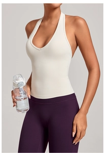 Détail du débardeur de yoga col en V crème et legging violet avec un éclairage doux