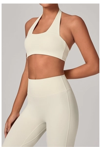 Dettaglio del reggiseno sportivo allacciato al collo e leggings a vita alta crema