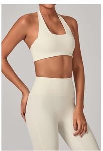 Dettaglio del reggiseno sportivo all'americana traspirante e dei leggings yoga crema