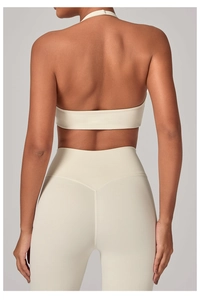 Vista posteriore del reggiseno yoga allacciato al collo e leggings a vita alta crema