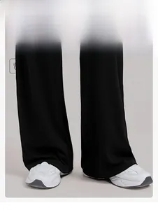 Detailweergave van de zwarte yoga-broek met wijde pijpen en soepel vallende stof