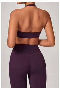 Dettaglio del reggiseno sportivo prugna con schiena scoperta e leggings a vita alta