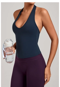 Détail d'un haut de yoga bleu marine et d'un legging violet sur un modèle de fitness