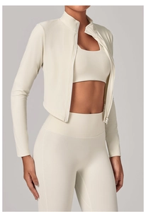 Détail de la veste à col montant zippé et du legging de yoga taille haute blanc crème
