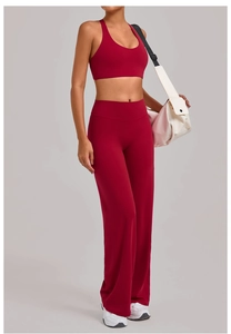 Detail van de flared yogabroek met hoge taille en racerback sportbeha in dieprood