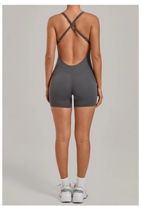 Detail of cross back straps and open back design on a dark gray yoga bodysuit