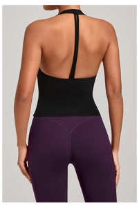 Détail du haut de yoga noir et du legging violet à taille haute sur un mannequin femme