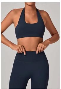 Dettaglio del reggiseno sportivo blu navy con scollo all'americana e leggings yoga a vita alta