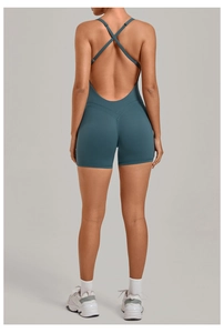 Detail view of teal yoga romper featuring cross-back straps and deep U-shaped back design