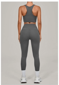 Detail of dark grey yoga set featuring racerback sports bra and high waisted leggings