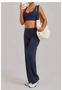 Detail van een uitlopende yoga broek met hoge taille en sportbeha in mat marineblauw