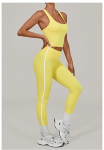Detailed close-up of vibrant yellow high-waisted yoga leggings with white side stripes