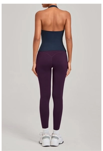 Détail d'un haut de yoga dos nu bleu marine et legging violet sur un mannequin femme