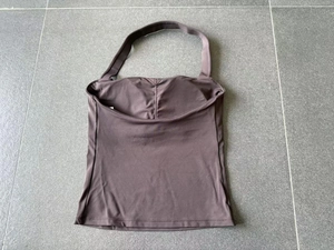 Vue détaillée à plat d'un débardeur de yoga marron foncé avec coussinets intégrés