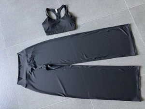 Gedetailleerde flat lay van zwarte yoga-set met racerback sportbeha en wijde broek