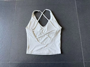 Détail des bretelles croisées et du dos ouvert sur le débardeur de yoga blanc crème