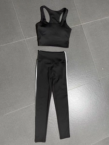 Flat lay of black yoga set featuring racerback sports bra and leggings with side stripes