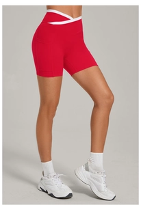 Detail der roten Yoga-Shorts mit hohem Bund, weißem V-Kreuz-Design und praktischer Seitentasche