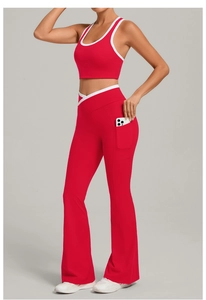 Detail showing red yoga pants with side pocket holding a smartphone and cross waist design