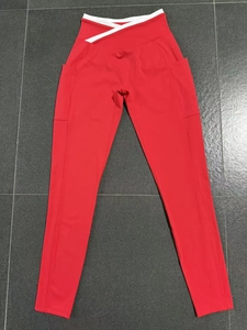Détail du legging de yoga rouge avec taille croisée blanche et poches latérales