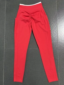 Détail du legging de yoga rouge foncé avec couture push-up et poches latérales