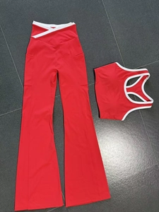 Flat lay of red yoga set with U-neck tank top and V-waist flared pants on grey tile
