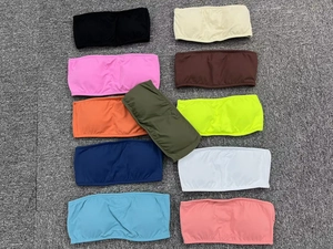 Flat lay display of strapless seamless yoga bras in eleven vibrant solid colors