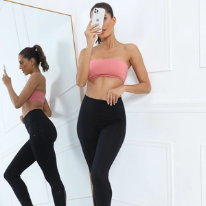 Close-up of pink strapless sports bra and black high waist leggings in mirror reflection
