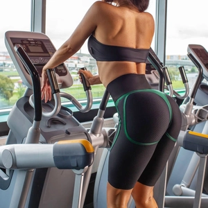 Détail du short de sport noir taille haute à texture nid d'abeille avec bordure verte sur elliptique