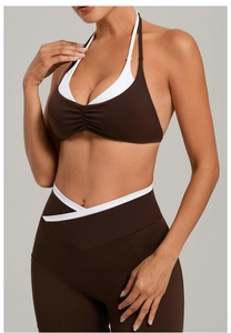 Detail der Kontrastpaspel an dunkelbraunem Halter-Sport-BH und High-Waist Yoga-Leggings