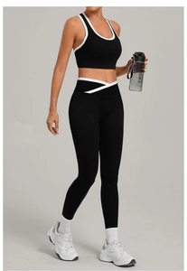 Details des schwarzen Sportsets mit weißer Paspelierung und stylischem Crossover-Bund