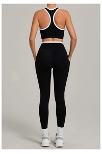 Rückansicht eines schwarzen Yoga-Sets mit weißem Kontrastbesatz an Sport-BH und Leggings