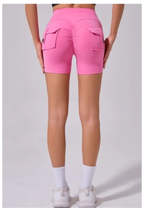 Close-up of pink scrunch butt yoga shorts featuring functional cargo back pockets