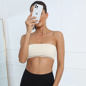Detail of beige strapless yoga tube top made of elastic ribbed fabric on model