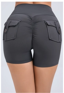 Detail view of high waist scrunch butt gym shorts in dark grey with button cargo pockets
