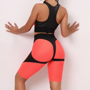 Detail view of honeycomb mesh fabric and booty lifting seams on neon orange yoga set
