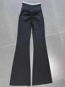Detail of flared yoga pants showing white contrast crossover waist and ruched booty lifting seam