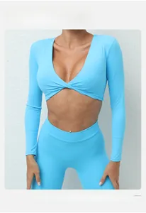 Détail du haut de yoga bleu clair avec un nœud élégant à l'avant et col en V